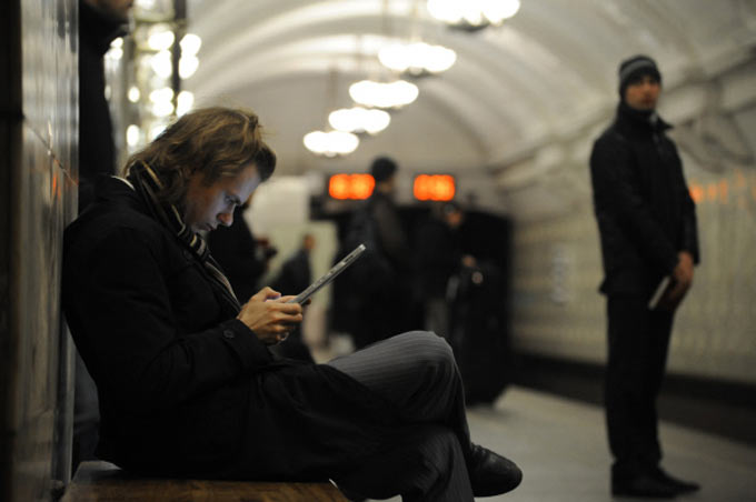 Пассажир пользуется планшетным компьютером на одной из станций метрополитена Фото: Александр Кожохин РИА Новости