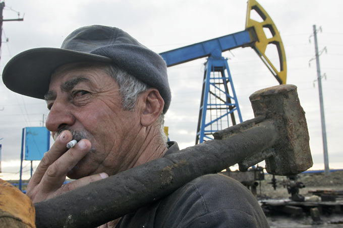Рабочий во время работы на нефтяной вышке. Дмитрий Лебедев/Коммерсантъ
