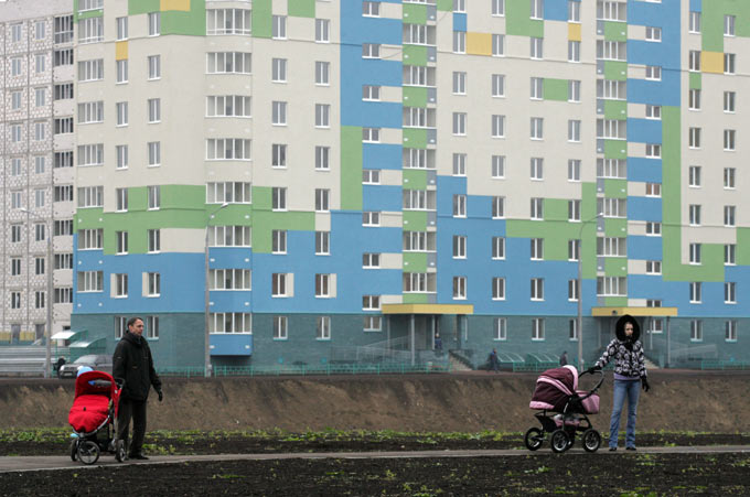 Двое с детскими колясками стоят на фоне новостройки. Фото: Роман Яровицын/Коммерсантъ