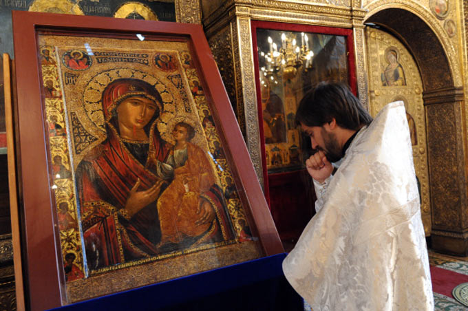 Священнослужитель возле чудотворной иконы Сергей Пятаков\РИА Новости