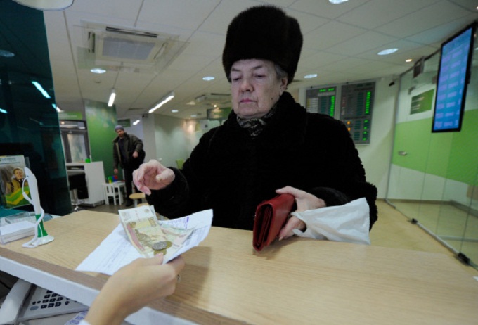 Женщина оплачивает жилищно-коммунальные услуги в отделении Сбербанка России, Григорий Сысоев РИА Новости